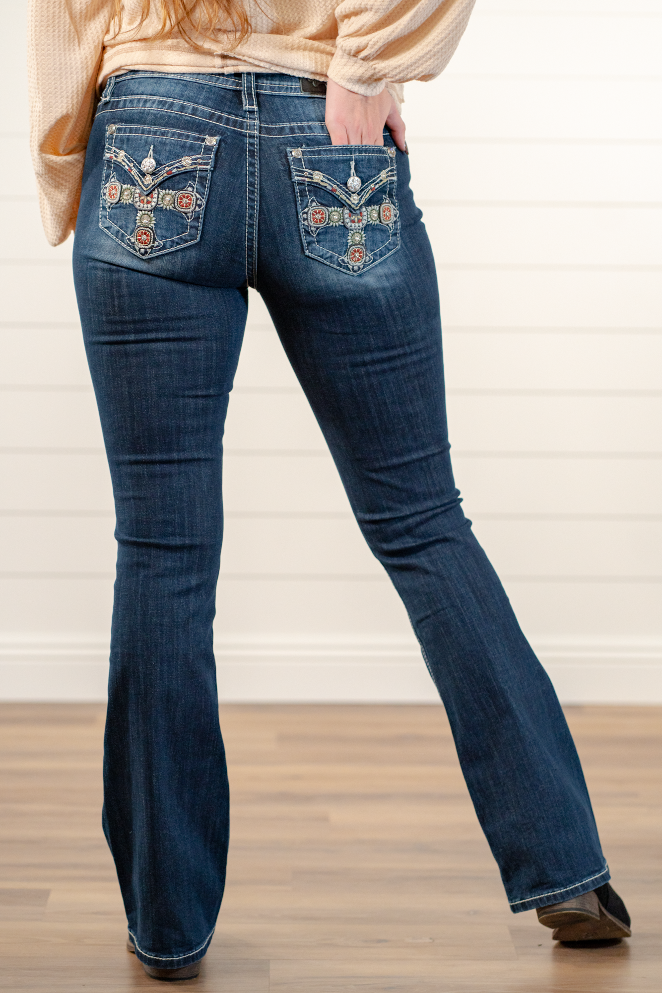 Miss Me  Wear these cross pockets jeans every day to bling up your wardrobe. Boot cut jeans featuring a 5 pocket design, whiskering, and crystal rivets. Wash: Dark Blue Inseam: 34" Boot Cut* Mid Rise, 8.75" Front Rise* Silver Buttons and Rivets  Material: 98% Cotton 2% Elastane Style #: M3824B   Contact us for any additional measurements or sizing.    *Measured on the smallest size, measurements may vary by size.  
